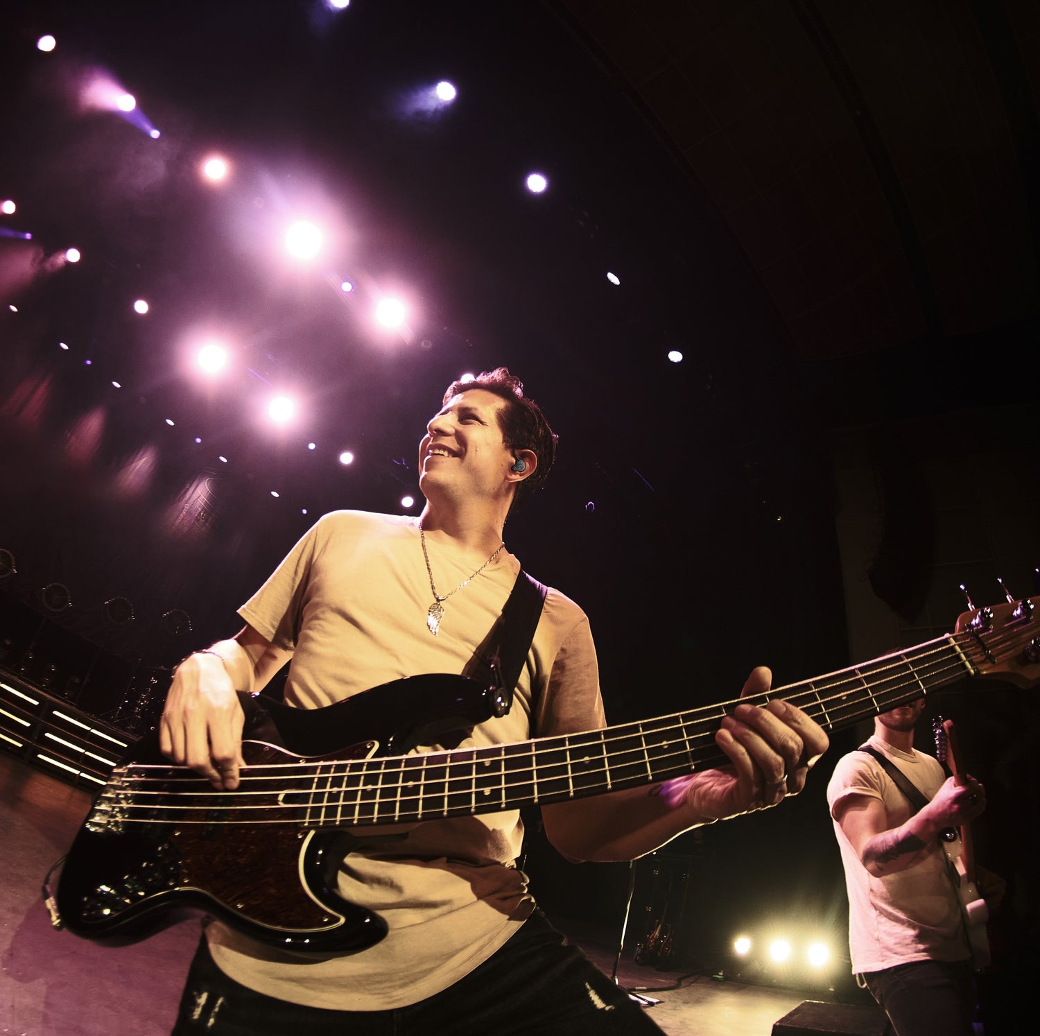 Justin Kudding playing bass guitar on stage.