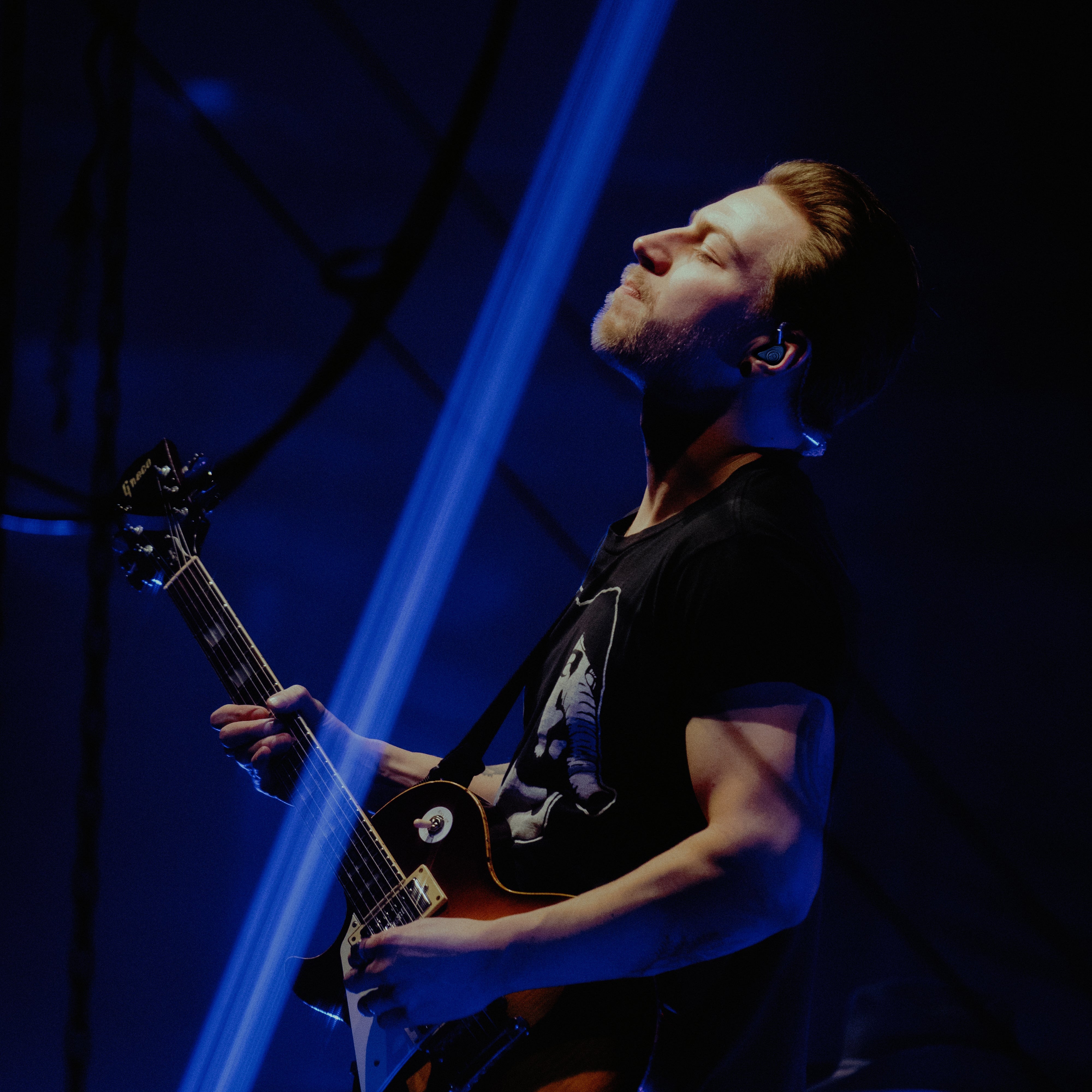 Man plays guitar with his eyes closed.
