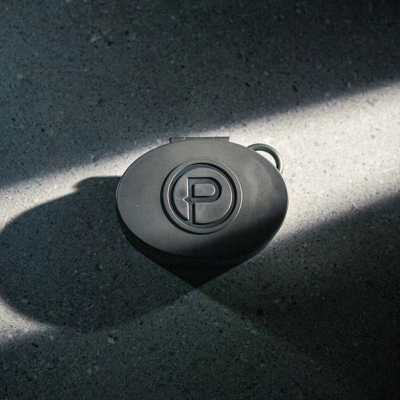 Plunge Audio black IEM case on pavement with spotlight.