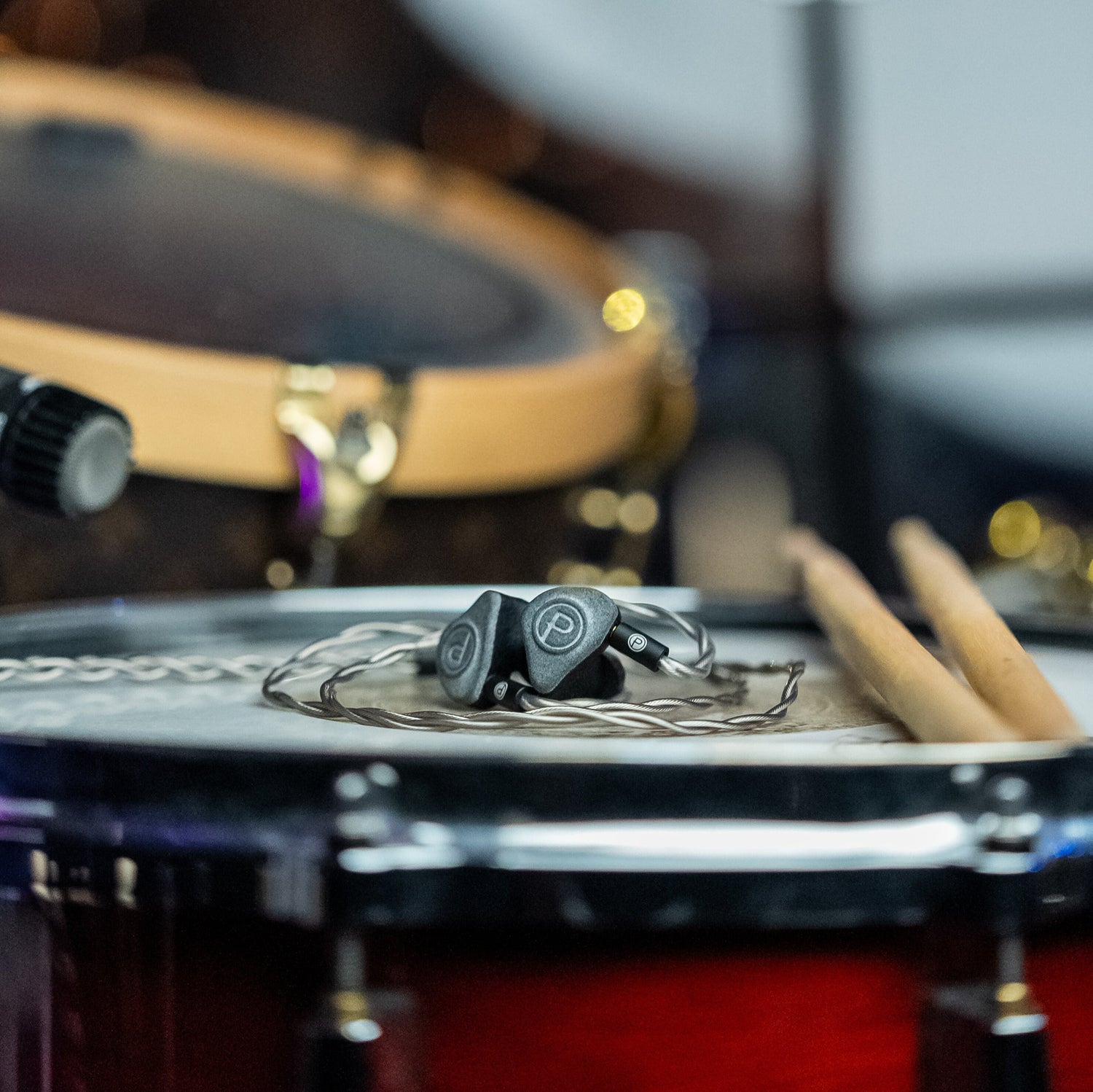 Plunge Audio IEMs resting on drum kit.