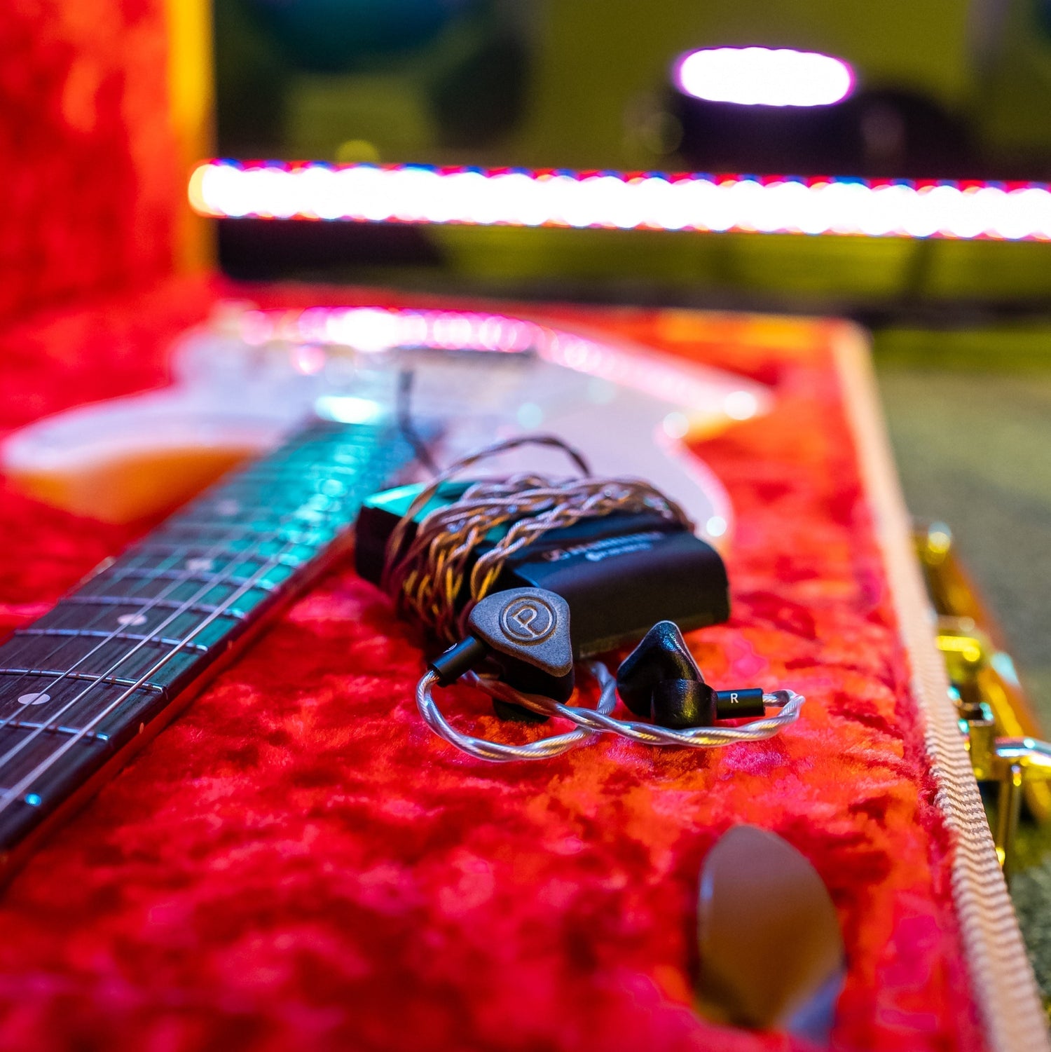 IEMs wrapped around back laying on guitar case.
