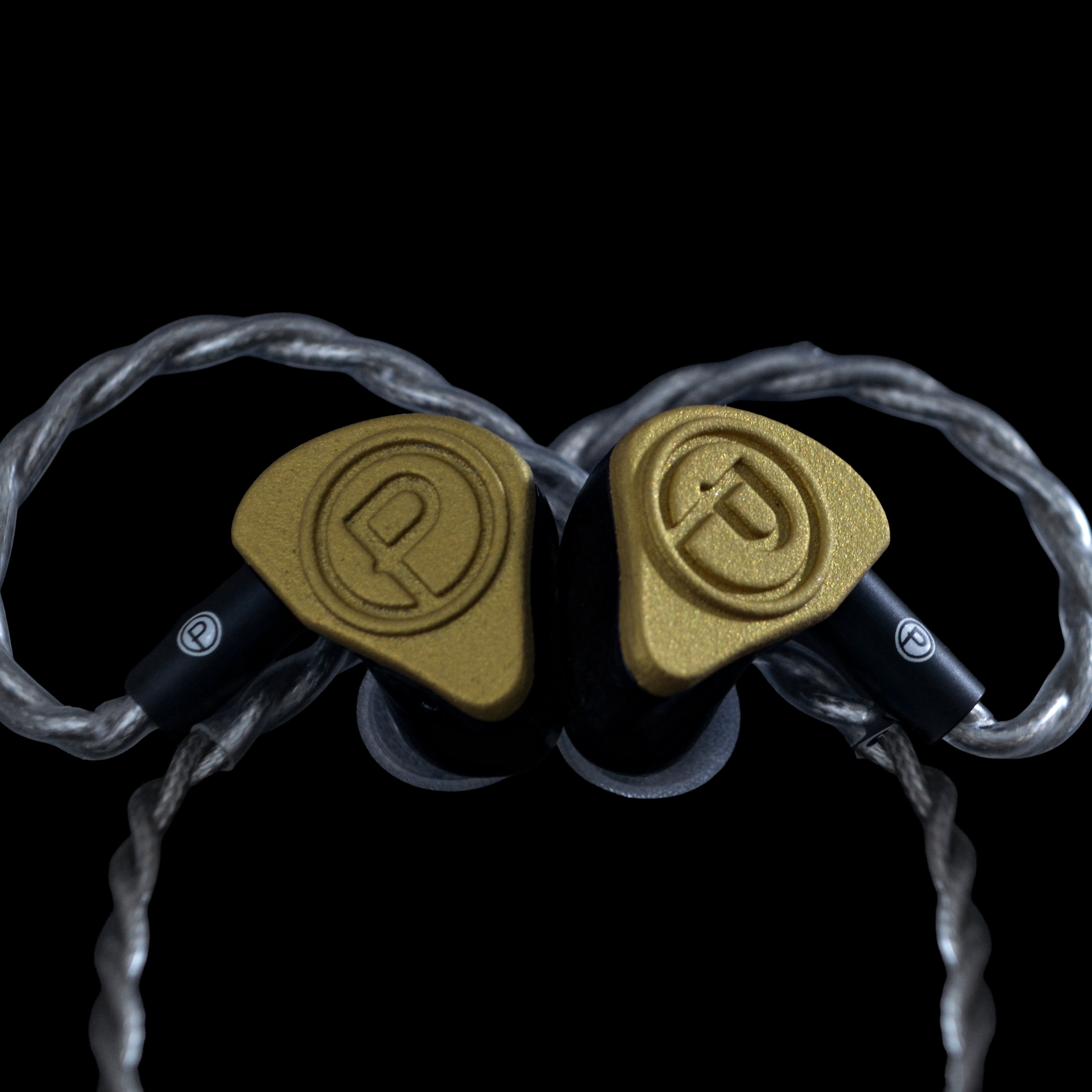 Gold in-ear monitors on a black background