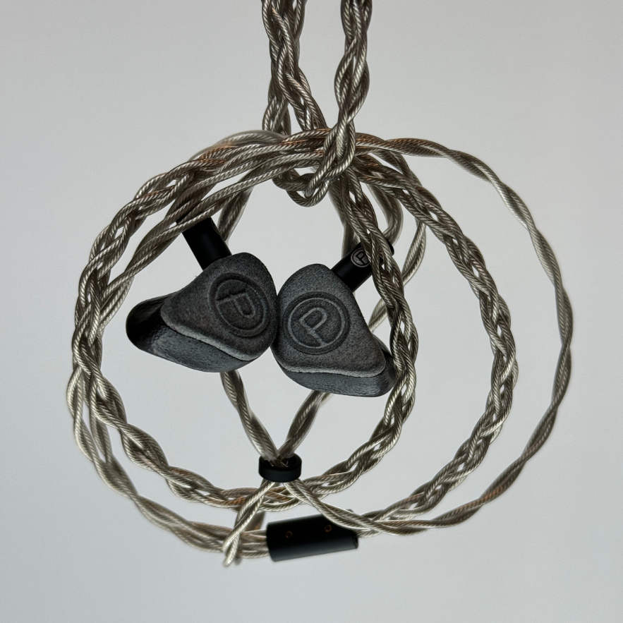 Plunge Audio IEMs arranged in a spiral on a grey background, highlighting sleek design and advanced audio technology.