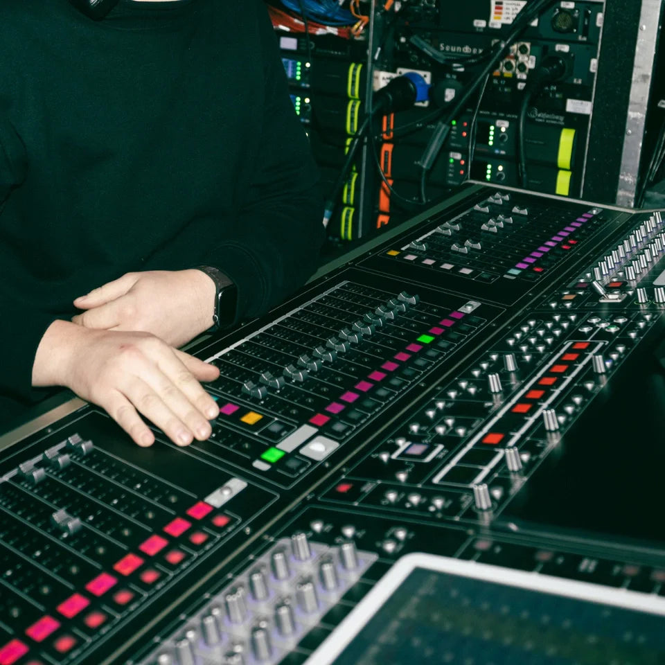 Technician adjusting levels on a sound board.