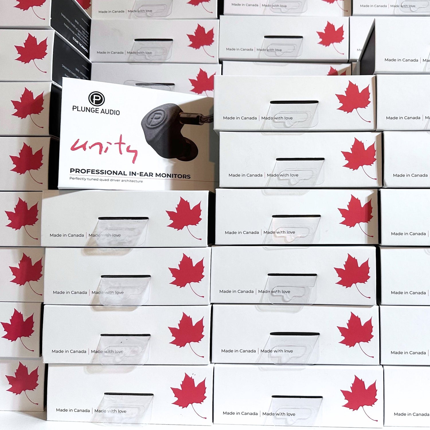 Stacked white Plunge Audio IEM boxes featuring a maple leaf design.