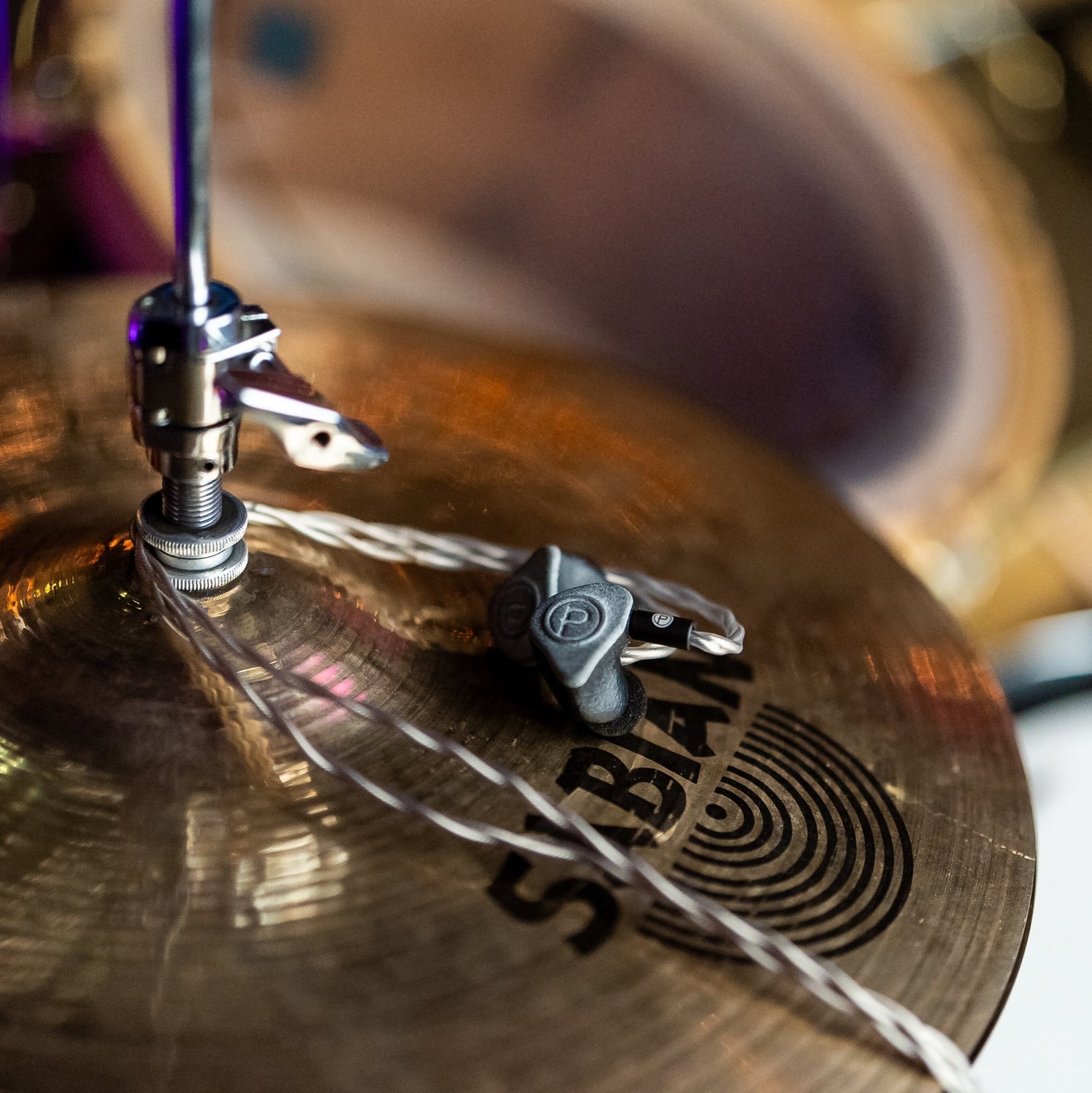 Plunge Audio IEMs resting on gold cymbals.