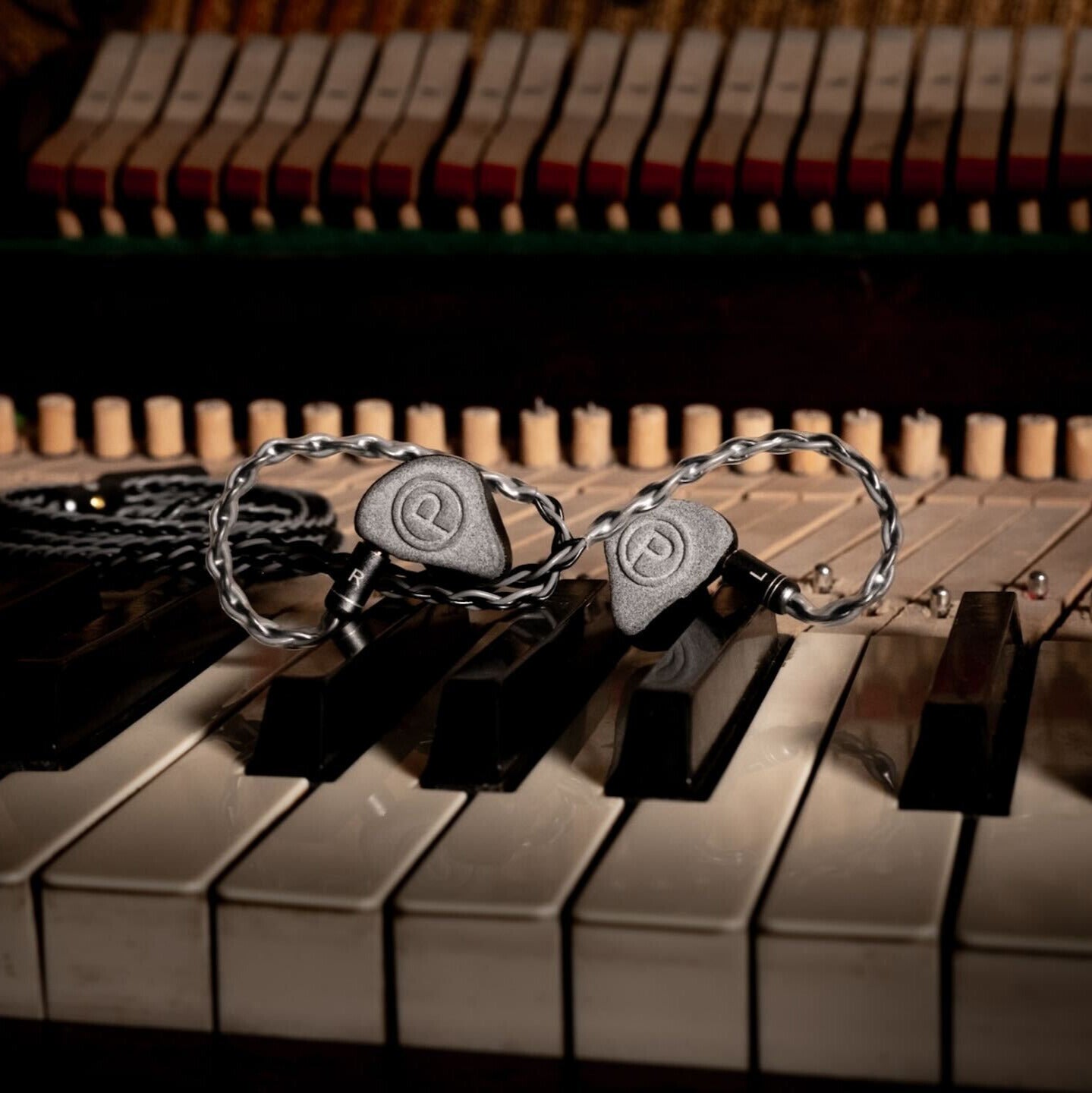 Plunge Audio IEMs resting on piano keys.